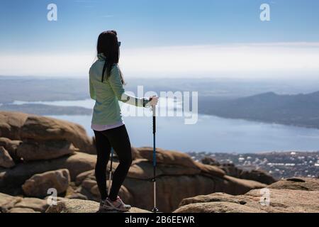 Panoramablick auf eine junge Frau in La Pedriza mit dem Santillana-Reservoir, Manzanares El Real, Madrid, Spanien. Stockfoto