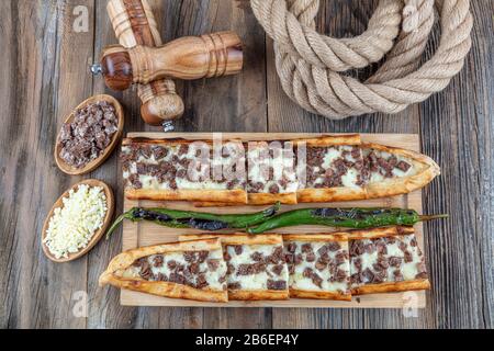 Türkisches Pide mit lang geröstetem und geröstetem Pide. In Steinofen mit Cheddar-Käse gebacken. Türkischer Name; Kazurmali Kasar peynirli pide. Stockfoto