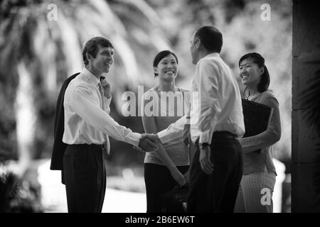 Führungskräfte begrüßen sich vor dem Gebäude. Stockfoto