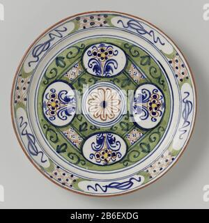 An Bord von Rond bord van veelkleurig beschilderde faience, met op het plat een zirkel Stockfoto