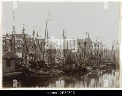 Boote im Damrak, die mit Flaggen zur Einweihung der Boote der Königin Wilhelmina, Amsterdam, Niederlande im Damrak dekoriert sind, sind anlässlich der Einweihung der Königin Wilhelmina mit Flaggen verziert. Auch im Haus am Damrak und im Victoria Hotel (rechts) steckte seine Fahne. Ganz rechts Teil des Hauptbahnhofs, Amsterdam, Niederlande Hersteller Schöpfer: Fotograf: Anonymer Ort Herstellung: Amsterdam Datum: 1898 Physische Merkmale: Dolchcollodiumzilverdruk auf Papiermaterial: Papiertechnik: Dolchcollodiumzilverdruk Abmessungen: Foto: H 120 mm × W 162 mm Stockfoto