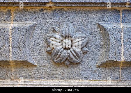 Ein Reliefschmuck aus geblümtem Sandstein an einem alten Gebäude. Stockfoto