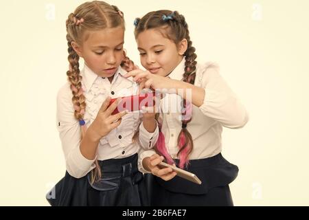 Mädchen Schuluniform im Internet surfen. Das moderne Leben. Schülerinnen mit Mobile Internet smartphone. Schule Anwendung smartphone. Mobile sucht. Weltweites Netz. Internet Ressource hat Gefahren für Kinder. Stockfoto