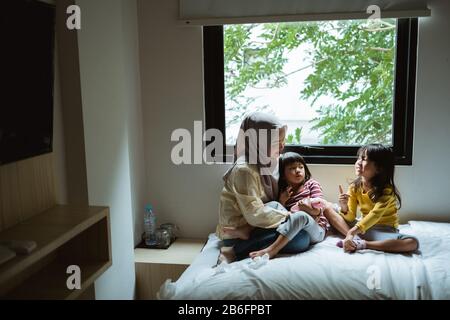 Die Mutter erzählt ihrer Tochter auf dem Bett, spielt zusammen Stockfoto