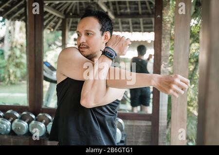 Asian man streckt sich vor dem Training im Fitnessstudio Stockfoto