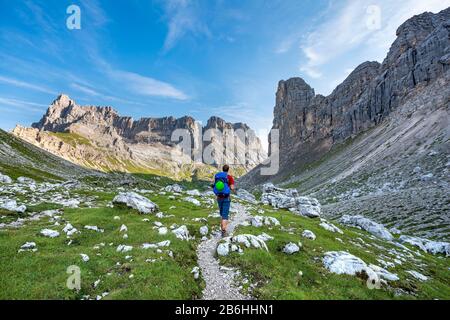 Wanderer, Bergsteiger auf einem Weg zwischen felsigen Bergen bei Forcella Grande, Sorapiss Circuit, hinter dem Berg Punte Tre Sorelle, in den Bergen, Belluno, Italien Stockfoto