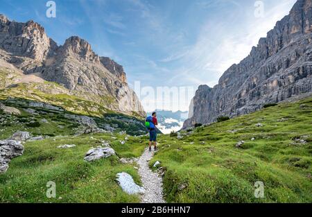 Wanderer, Bergsteiger auf einem Weg zwischen felsigen Bergen, Sorapiss-Rundkurs, hinter dem Berg Punte Tre Sorelle, den Doles, Belluno, Italien Stockfoto