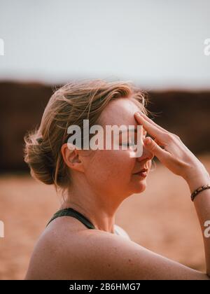 Eine Frau, die einen privaten Yoga-Kurs am Strand führt In Westaustralien Stockfoto