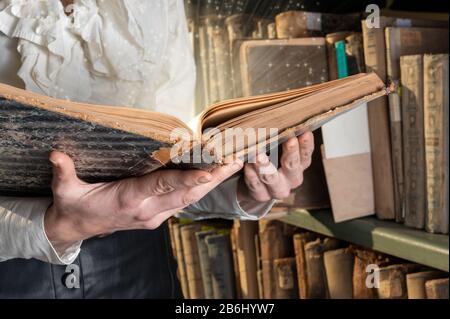 Licht aus altem Buch in den Händen der Frau, Begriff der Weisheit, des Lesens, der Phantasie. Stockfoto