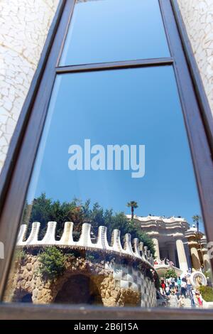 Zerbrochene Glasmosaikfliesen als Keramikkunst an der Gebäudewand und Spiegelung des Glasfensters im Park Guell, Barcelona, Spanien Stockfoto