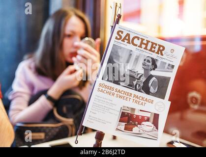 24. MÄRZ 2017, WIEN, ÖSTERREICH: Eine Frau sitzt am Tisch mit einer Speisekarte im berühmten Sacher Cafe in Wien Stockfoto