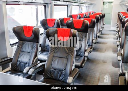 Das Innere des Wagens in einem Business-Class- oder Luxuszug mit weichen leeren Sitzen Stockfoto