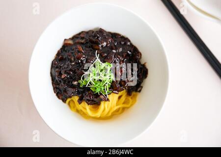 Draufsicht Bild der traditionellen koreanischen Küche, Jajjangmyeon schwarze Nudel auf einer weißen Schüssel Stockfoto