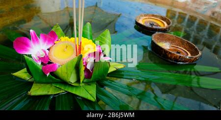 Krathong, handgefertigter schwimmender Korb mit Bananenblatt, dekoriert mit Blumen und Räucherstäbchen, Kerze, Licht und Schwimmer auf dem Wasser, um das fest zu feiern Stockfoto