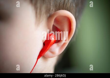 Kleine Jungen- und Ohrhörer Stockfoto