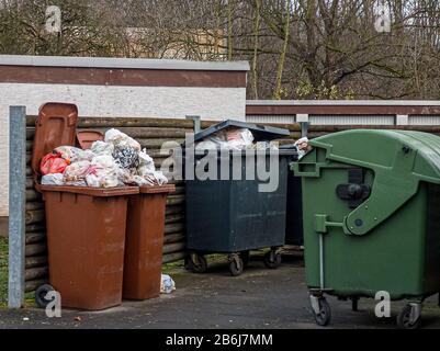 Mülltonnen in verschiedenen Farben gefüllt bis überströmt als Zeichen für eine wohlhabende Gesellschaft Stockfoto