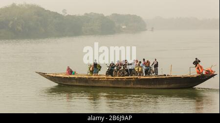 Murshidabad, Westbengalen/Indien - Januar 14 2018: Ein großes Holzboot bringt Passagiere, Motorräder und Fahrräder über den Hooghly-Fluss. Stockfoto