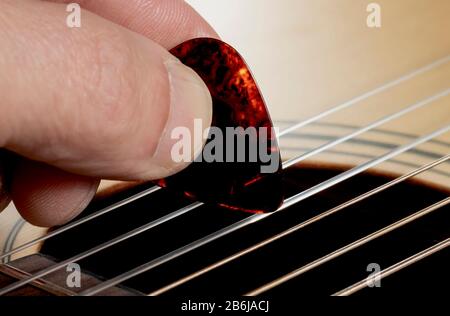 Gitarrist spielt Gitarre auf hölzernen Hintergrund, Nahaufnahme. Stockfoto