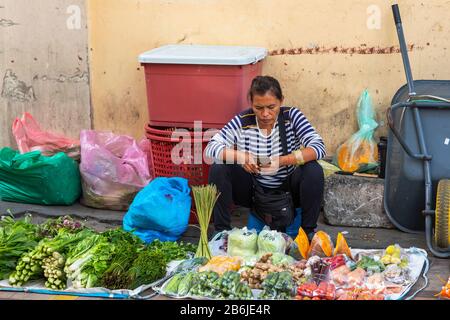 Lokale Frau, die frisches Gemüse auf dem Straßenbelag verkauft, Sandakan, Sabah District, Malaysia, Asien Stockfoto