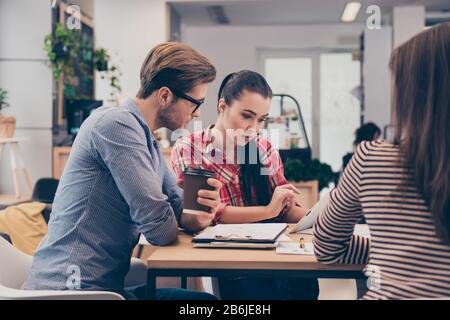 Team junger konzentrierter Studenten, die am College an einem Projekt arbeiten Stockfoto