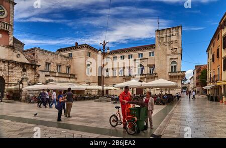 Zadar, Provinz Dalmatien, Kroatien, Narodni trg ist das Zentrum des öffentlichen Lebens in Zadar von der Renaissance bis heute. Auf dem Gelände des großen Platzes, der Platea magna, wurden im frühen Mittelalter die Grundmauern städtischer Institutionen gelegt. Danach wurden hier die Stadtloge und die Kirche St. Peter der neue errichtet. Sie wurden während der Herrschaft Venetiens im 15. Jahrhundert von den Behörden zerstört. Im 16. Jahrhundert wurde das Gebäude der Stadtwache (Gradska straža) mit dem Uhrturm der Stadt erbaut. Stockfoto