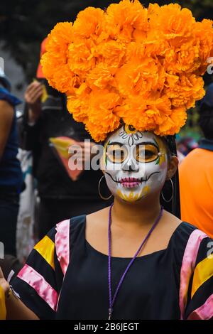 Mexiko-Stadt, Mexiko,; 26. Oktober 2019: Schöne Frau als catrina gekleidet mit Blumenschmuck auf dem Kopf in der Prozession der Katrinen in mexiko Stockfoto