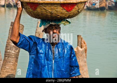 Labore entladen verschiedene Fischarten aus dem Fischerhafen. Fisch ist ein großes Mittel zur Bekämpfung der Ernährungsunsicherheit und des Klimawandels in Bangladesch. Stockfoto