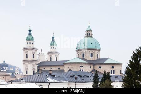 Über den umliegenden Gebäuden in der Salzburger Altstadt steht der Salzburger Dom, ein im Stil des Barock errichteter, römischer Dom. Stockfoto