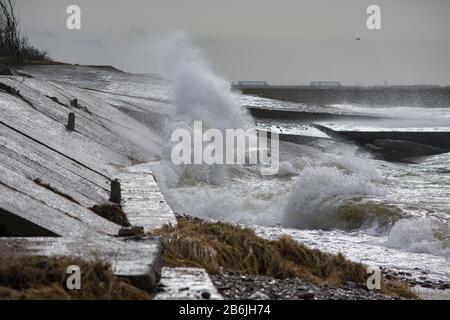 Große Wasserspritzer. Wellen schlagen auf Betonsteg an der Meereswand Stockfoto