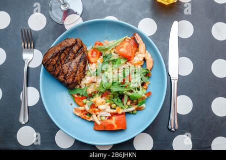 Rindersteak mit Salatreis auf einem Teller Stockfoto