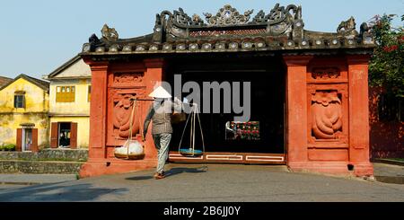 Straßenverkäufer, der in einer Brücke in der Straße von hoi an-vietnam kommt Stockfoto