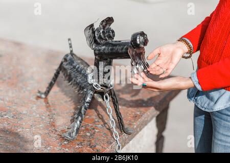 28. APRIL 2018, UFA, RUSSLAND: Frau berührt kleine Hutstatue eines Hundes Stockfoto