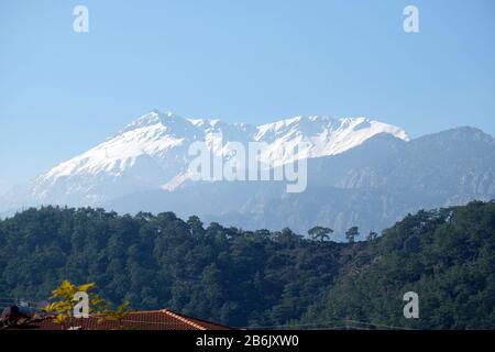 Panoramalandschaft mit türkischen Bergen unterschiedlicher Höhe, Bergkiefern an den hängen und Schnee auf hohen Gipfeln bei weitem Stockfoto