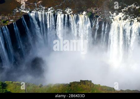 Victoria Falls Luftaufnahme in der Grenze von Simbabwe und Sambia in Afrika mit einem beeindruckenden Volumen von Wasser fließt. Wassernebel vom Wasserfall. Stockfoto