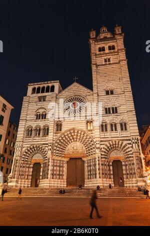 Genua, Italien - 17. Januar 2018: Kathedrale von Genua oder Cattedrale Metropolitana di San Lorenzo. Nächtlicher Straßenblick auf die alte Genova mit Wanderern Stockfoto