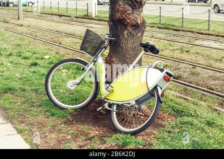 Ein Fahrrad zum Mieten in der Nähe des Baums in der Stadt Stockfoto