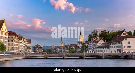 Panoramablick auf die berühmte Fraumunster und die Kirche St. Peter und Limmat bei Sonnenaufgang in Der Altstadt von Zürich, der größten Stadt der Schweiz Stockfoto