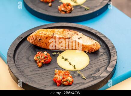 Gebackenes Lachsfilet mit Rosmarin und Sufte auf Holzplatte Stockfoto