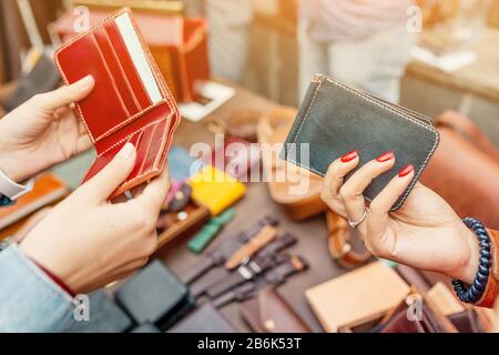 Frau entscheidet sich für handgefertigte Ledertasche auf dem Straßenmarkt Stockfoto