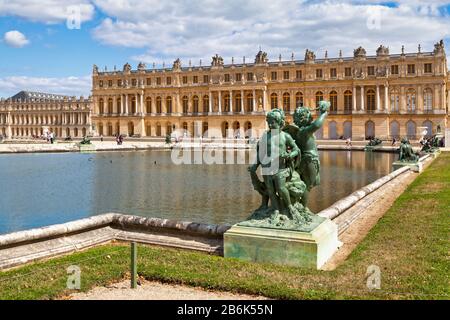 Versailles, Frankreich - 20. August 2017: Bronzestatue von drei Cherubs, die am Rande eines Beckens des Bassin du Midi in den Gärten von Versailles aufgestellt wurden, Stockfoto