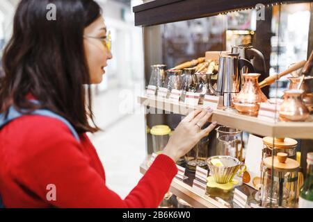 Kunde der asiatischen Hipper, die alte Vintage-Bronze-Zves auf dem orientalischen Retro-Markt wählen Stockfoto