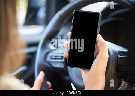 Telefonverhöhung im Auto. Mietwagenfahrer Stockfoto