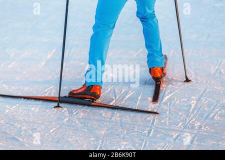 Nahaufnahme von Skilanggeräten - Stiefel und Stöcke auf Schneegrund Stockfoto