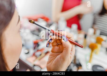 Junge Frau, die ihre Augenbrauen mit einer Bürste aufrüstet Stockfoto