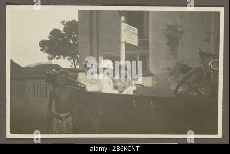 Drei sitzen auf dem Rücksitz eines Autos, vor einem Jungen Zwei Frauen und ein Mann, alle in westlicher Kleidung, sitzen auf dem Rücksitz eines Cabriolets. Im Vordergrund ein Junge mit Lointuch und Gürtel. Im Hintergrund eine Straße, teilweise auf Englisch. Teil des Familienalbums Dutch-Indië. Hersteller : Fotograf: Anonym Datum: 1920 - 1930 Physikalische Merkmale: Gelatine silberfarbenes Druckmaterial: Papiertechnik: Gelatine silberfarbenes Druckmaß: H 66 mm × W 110 mm Betreff: Auto (+ drei Personen  Verkehr und Transport) Wo: Sri Lanka Stockfoto