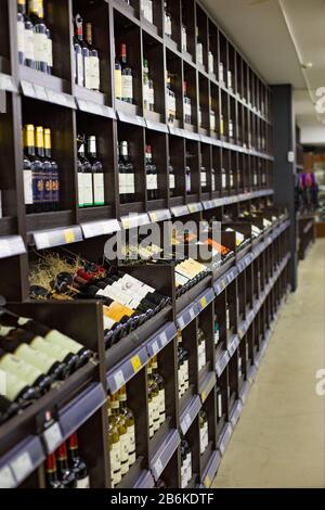 Moskau, Russland - 6. Januar 2020: Lagerhaus mit alkoholischen Prodktion in Glasflaschen, Trocken-Sekt-Wein-Tinktur-Hafen. Dunkle Regale Stockfoto