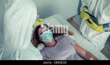 Patienten, die von Ärzten betreut werden, die prüfen, ob sie Fieber hat Stockfoto