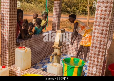 Bissau, Republik Guinea-Bissau - 6. Februar 2018: Frauen und Kinder am Brunnen für Wasser, in der Stadt Bissau, Guinea-Bissau Stockfoto