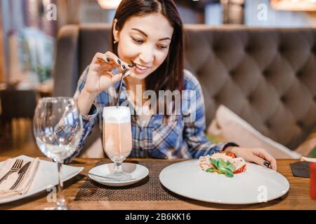 Ostfrau isst Spaghetti-Pasta mit Gabel im Luxusrestaurant Stockfoto