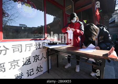 (200311) -- PEKING, 11. März 2020 (Xinhua) -- Gemeinschaftsarbeiter Liu Chun (L) hilft einem Einwohner, der gerade nach Peking zurückgekehrt ist, persönliche Informationen bei der Fensiting Community im Distrikt Dongcheng in Peking, Hauptstadt Chinas, am 10. März 2020 zu registrieren. Die Hutongs in Peking, dem meist geschäftigen Labyrinth traditioneller Gassen, wurden nach dem Ausbruch der neuartigen Coronavirus-Krankheit, kurz COVID-19, in China deutlich leiser. Seitdem bemühen sich die Gemeindearbeiter, das Sicherheitspersonal und die Freiwilligen, die Bedürfnisse der Bewohner zu erfüllen und gegen den Ausbruch des Virs zu kämpfen Stockfoto